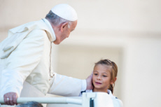 Le pape François bénissant une petite fille.