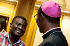 Synode des évêques au Vatican. Evêque africain parlant avec un jeune homme.