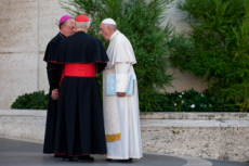 Synode des évêques. Le pape François converse avec un évêque et un cardinal.