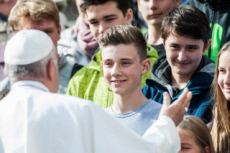 Le pape François salue des jeunes.