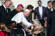 Le pape François benissant une personne âgée