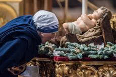 Missionnaires de la Charité embrassant le pied de l'Enfant Jésus.