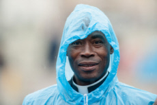 Prêtre avec imperméable bleu.