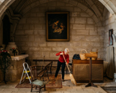 Femme dans l'Eglise. Membre de l'équipe paroissiale, balayant l'intérieur d'une église.