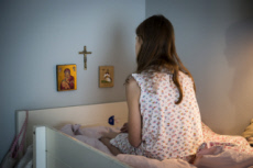 Religion, adolescente faisant une prière agenouillée dans son lit.