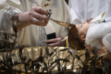 Le pape François baptisant un bébé.