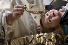 Le pape François baptisant un bébé.