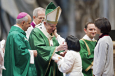 Geste de tendresse d'une fidèle qui caresse la joue du pape François.