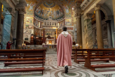 Prêtre arrivant dans une église vide où la messe sera filmée.