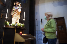 Coronavirus, fidèle, protégée par un masque, venue prier dans une église.