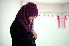 Jeune musulmane faisant la prière chez elle