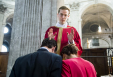 Un prêtre nouvellement ordonné, bénissant un jeune couple.