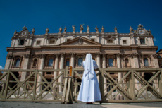 Une religieuse priant devant la basique Saint Pierre à Rome, Italie.