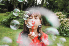 Fillette faisant des bulles de savon.