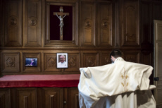 Prètre revêtant la chasuble dans la sacristie