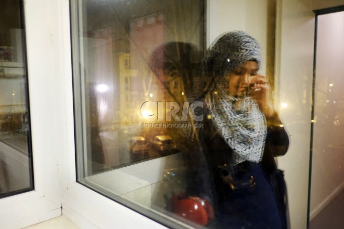 Jeune musulmane, au téléphone, chez elle.