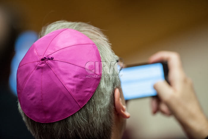 Un évêque consultant sur téléphone portable