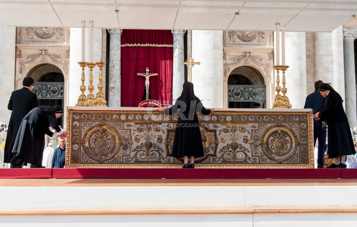 Des religieuses préparent l'autel avant la célébration de la messe au Vatican.