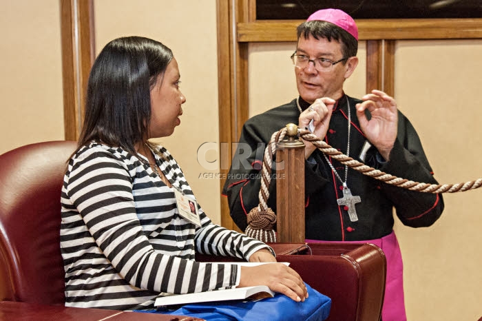 Synode des évêques au Vatican. Evêque parlant avec une jeune femme.