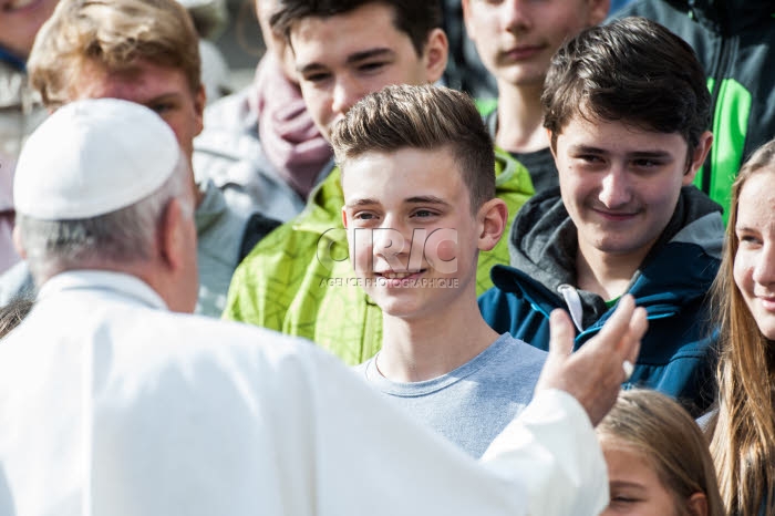 Le pape François salue des jeunes.