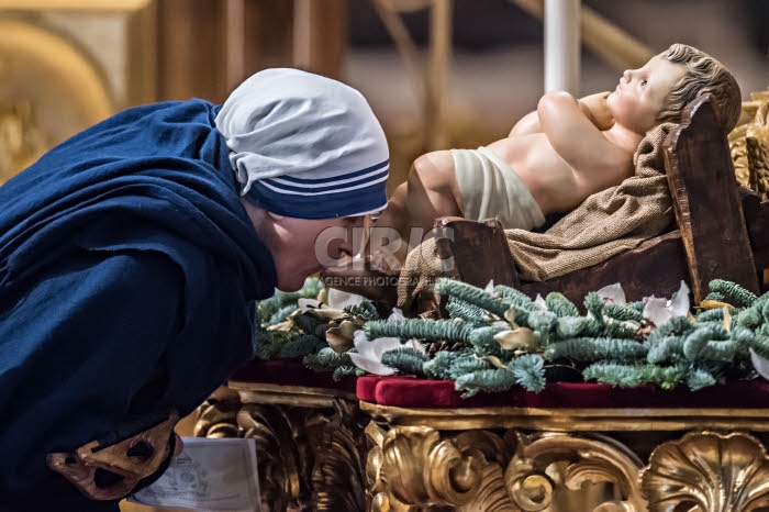 Missionnaires de la Charité embrassant le pied de l'Enfant Jésus.