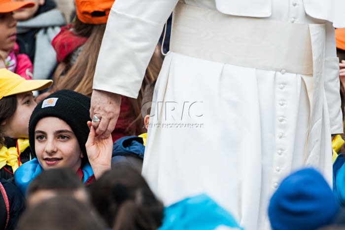 Un enfant tenant la main du pape François lors de l'audience générale.