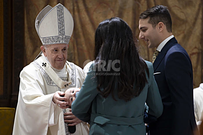 Le pape François baptisant un bébé.