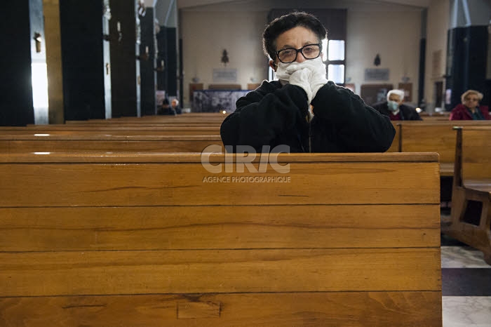Coronavirus, fidèle, protégée par un masque, venue prier dans une église.