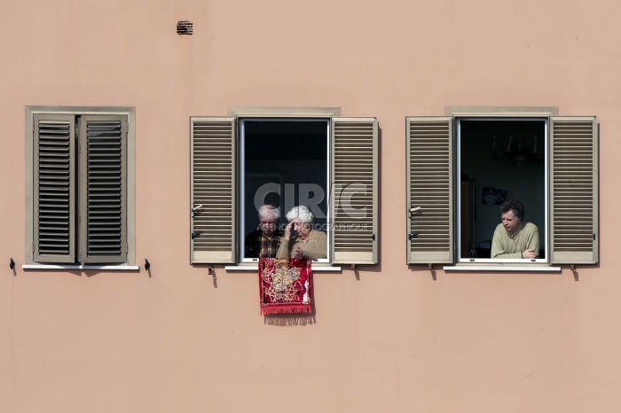 COVID-19. Habitants confinés écoutant la messe célébrée depuis un toit