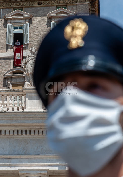 Prière de l'Angélus récitée par le Pape, et policier portant un masque.