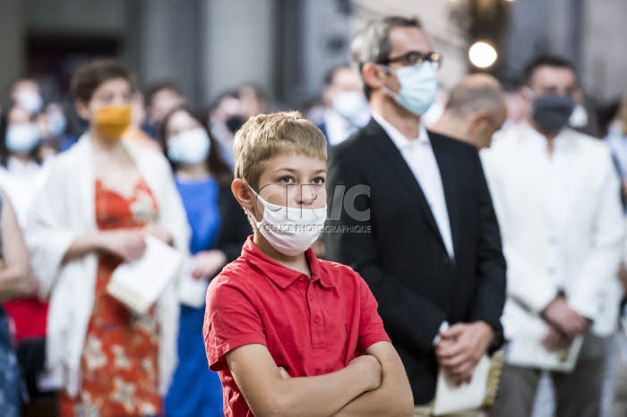 Covid-19, enfant avec masque de protection durant la messe.