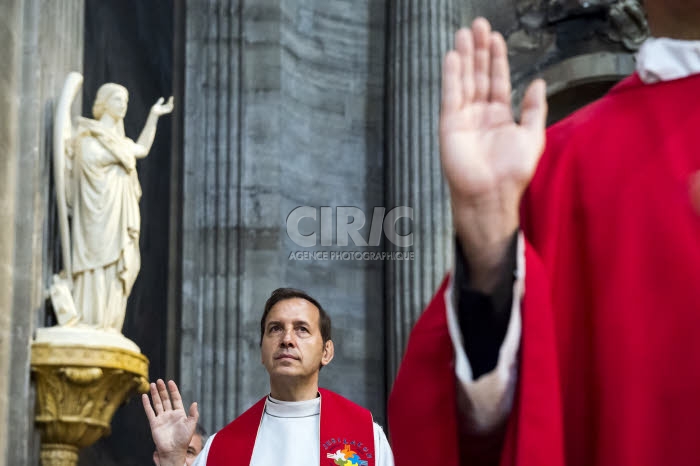 Prêtres levant la main durant la prière de l'ordination.