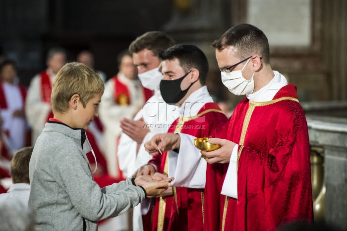 Covid 19, port de masques et communion donnée dans la main.