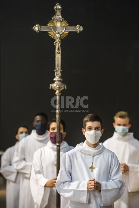 Covid-19, servant de messe portant un masque de protection.