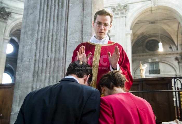 Un prêtre nouvellement ordonné, bénissant un jeune couple.