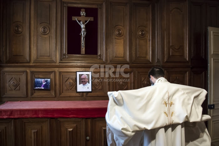 Prètre revêtant la chasuble dans la sacristie