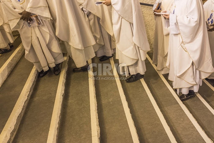 Groupe de prêtres portant des chasubles de couleur blanche.