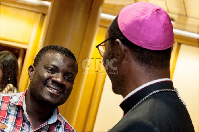 Synode des évêques au Vatican. Evêque africain parlant avec un jeune homme.