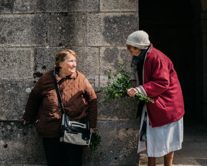 Deux paroissiennes discutent à la sortie de la messe des Rameaux.