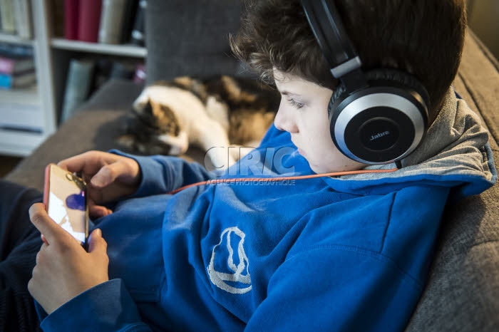 Adolescent jouant à un jeu sur son téléphone portable.