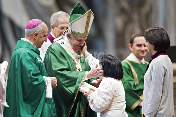 Geste de tendresse d'une fidèle qui caresse la joue du pape François.
