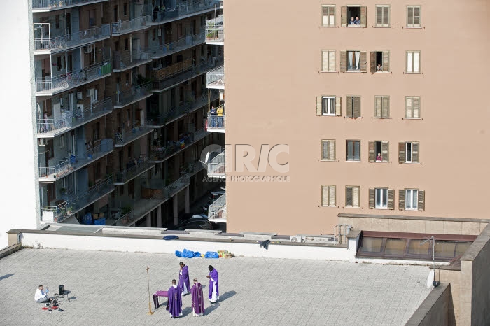 COVID-19. Prêtres célébrant la messe pour le quartier depuis le toit