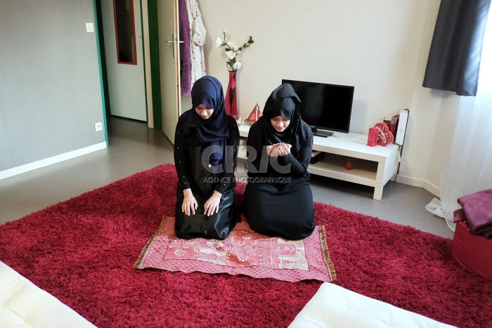 Jeunes musulmanes faisant leur prière chez elles.