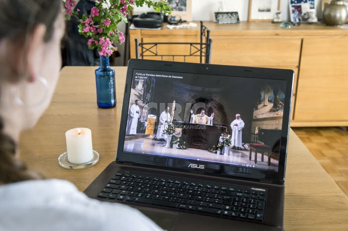 Catholique suivant la retransmission en direct de la messe de Pâques.