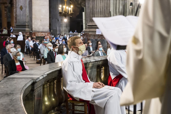 Ordinand avec masque de protection, lors de la messe.