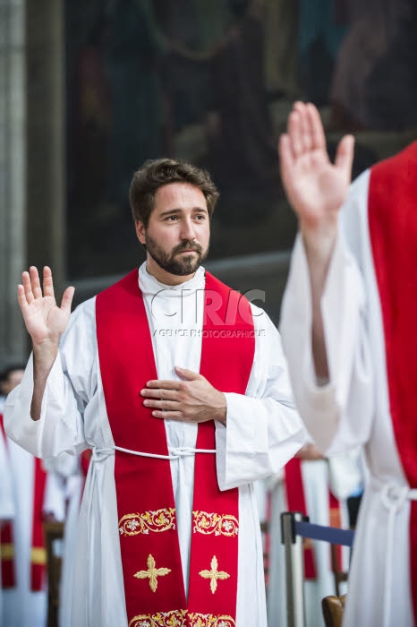 Prêtre levant la main durant la prière de l'ordination.