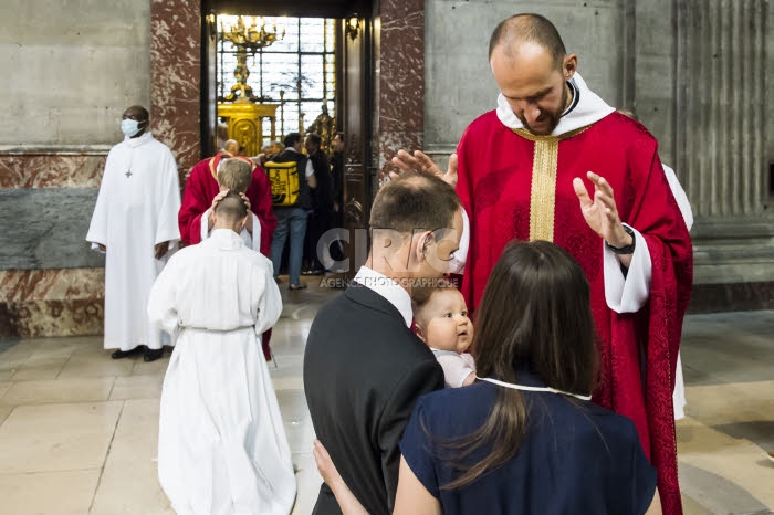 Un prêtre nouvellement ordonné, bénit une famille.