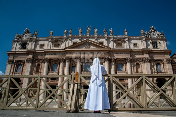 Une religieuse priant devant la basique Saint Pierre à Rome, Italie.